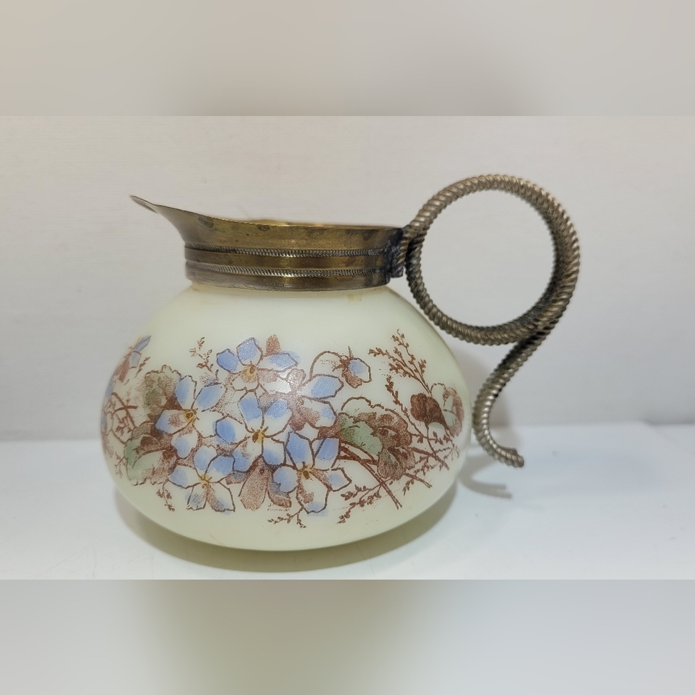 Antique wave crest creamer with brass trim and blue floral design